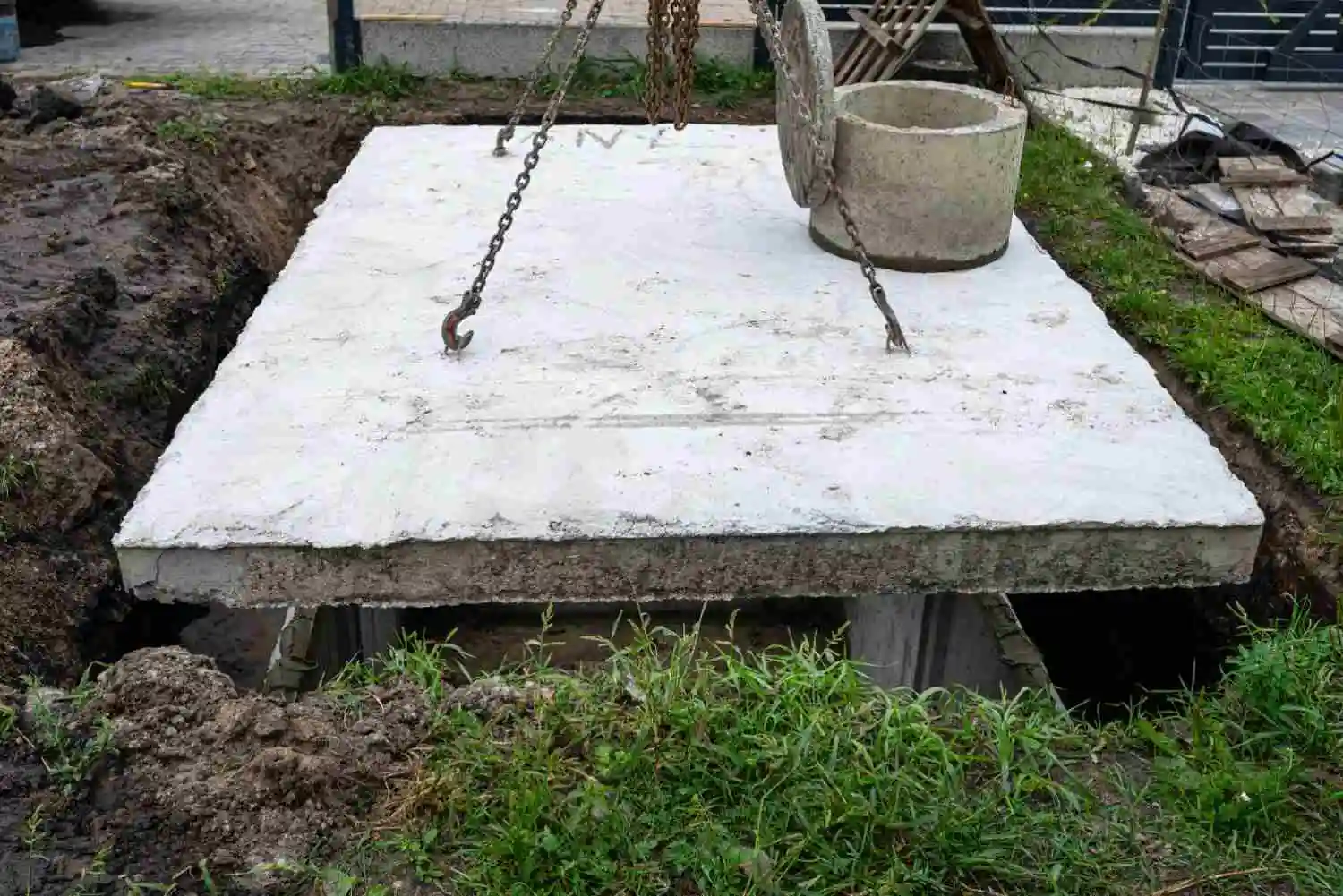 Heavy concrete slab with a manhole cover being installed, demonstrating how much a yard of concrete weighs.