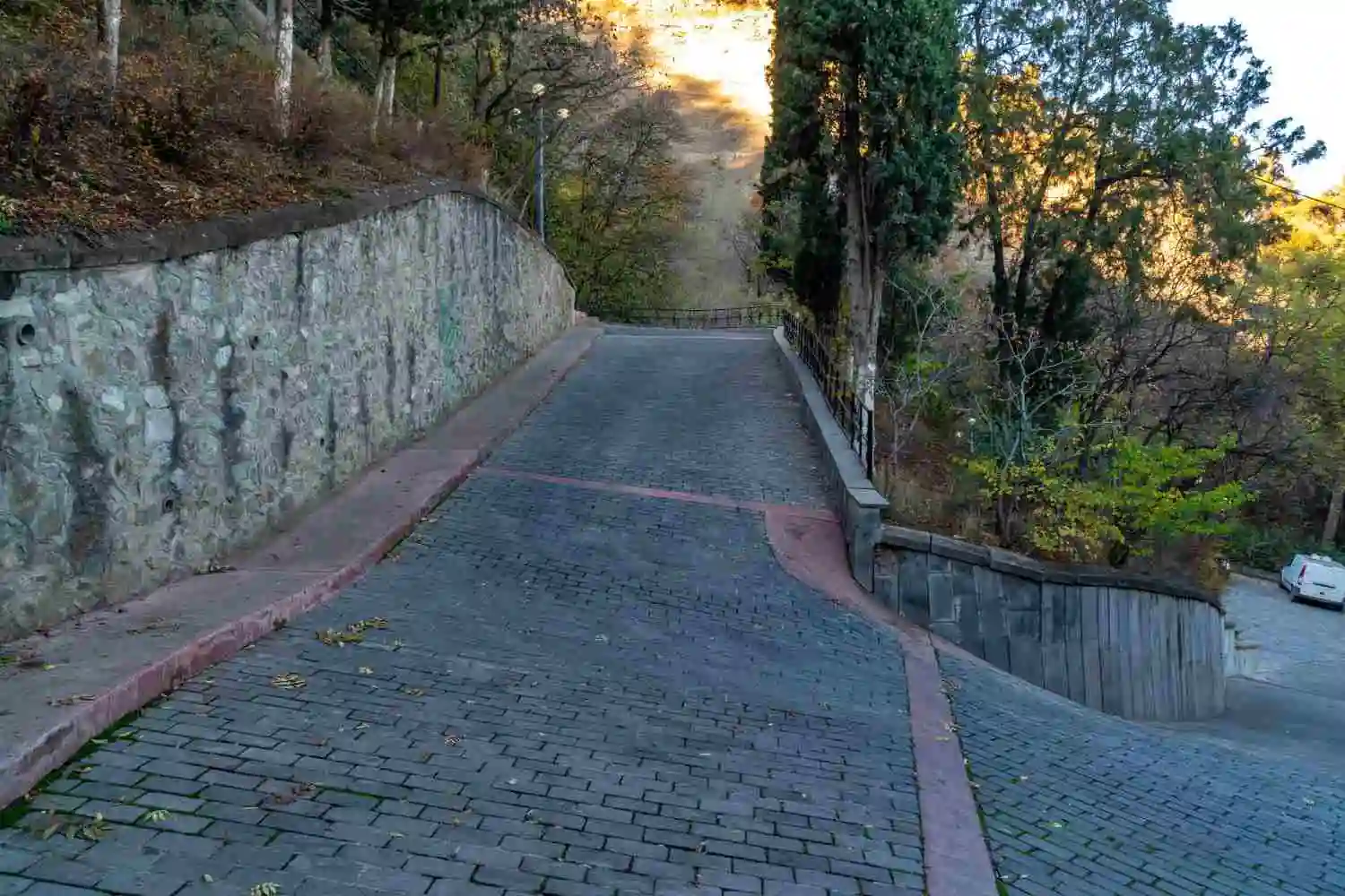 Cobblestone and stone paver walkway leading uphill, showing other materials sidewalks can be made of besides poured concrete.
